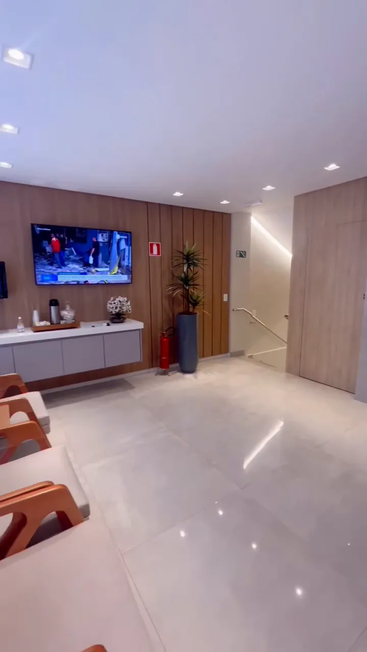 Recepção do Prevent Star com painel de madeira, TV e poltronas de couro.